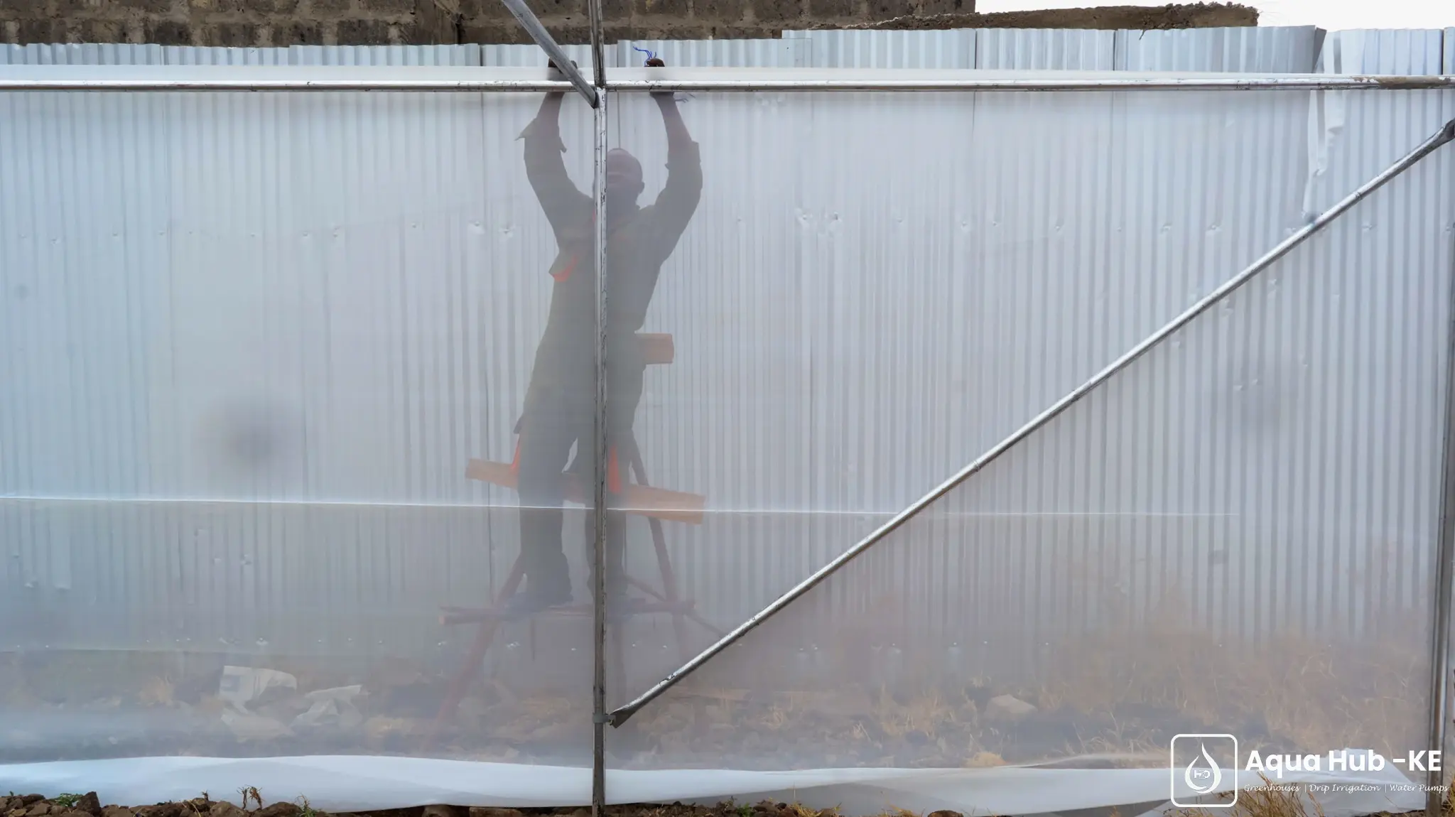 Netting installation to keep pests out of greenhouses in Kenya